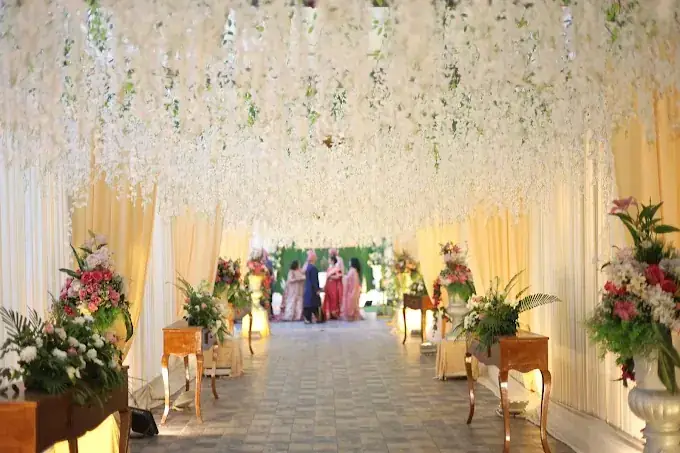 Hanging white floral canopy walkway leading to the wedding ceremony