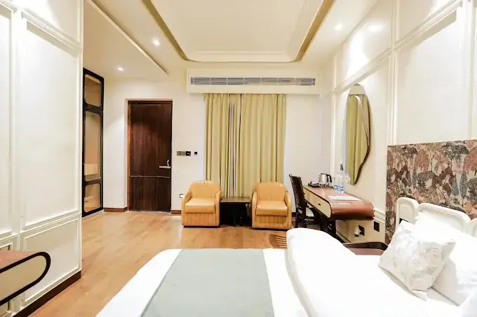 Deluxe room with lounge chairs, vanity and warm lighting