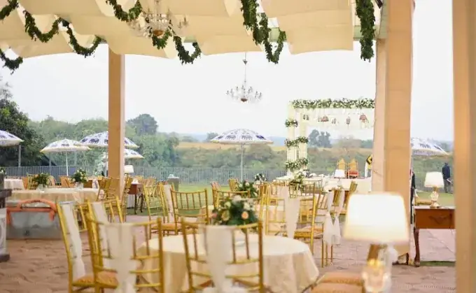 Hilltop covered lawn dining with gold chairs and chandeliers